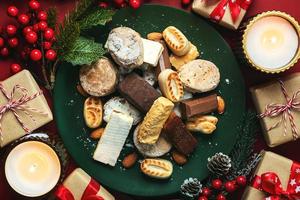 Top view of Nougat christmas sweet,mantecados and polvorones with christmas ornaments on a plate. Assortment of christmas sweets typical in Spain photo