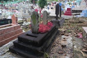 selective focus on black Muslim tombs made of ironwood. Muslim funerals in Indonesia photo