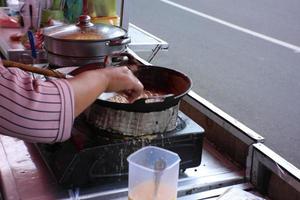 the seller of rolled omelet is frying the order photo