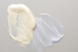 cosmetic smears of creamy textures om beige background. Skin care smears. Lotion, facial cleanser or cream smudges photo