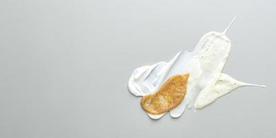 Composition of various cosmetic mask, creams, serum, scrubs and lotion smear on a gray background. Beauty texture. Sample of a cosmetic product. Banner photo