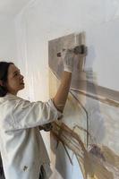 joven mujer latina, en su propio estudio de pintura, crea pinturas diferentes técnicas artísticas foto