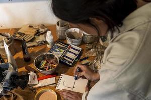 art workshop, messy objects, brushes, paint all mixed up disorganized, woman artist photo