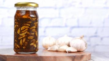 Peeled galric in jar with spices and oil, preserved video