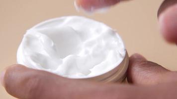 Dipping finger into thick skin cream moisturizer video