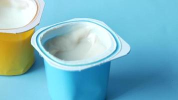 Yogurt containers on blue background video