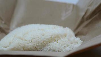una porción de arroz blanco al vapor en una bolsa marrón de papel encerado video