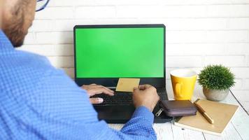 hombre escribiendo la información de su tarjeta de crédito en la computadora