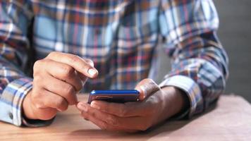 Mens in plaid overhemd gebruik makend van smartphone video