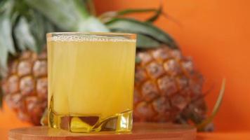 Pineapple juice on orange background