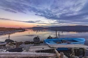 emocionante paisaje en un lago con muelle de madera y barco. foto