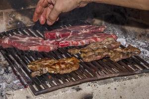 asar carne fresca en la chimenea. hacer barbacoa foto