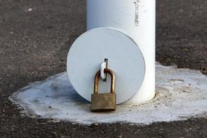 A rusty padlock hangs on a closed gate. photo