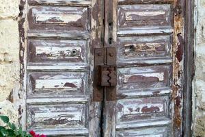 A rusty padlock hangs on a closed gate. photo