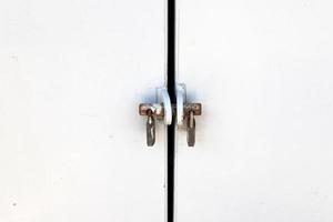 A rusty padlock hangs on a closed gate. photo