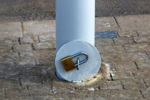 A rusty padlock hangs on a closed gate. photo