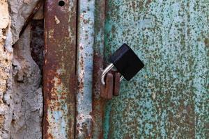 un candado oxidado cuelga de una puerta cerrada. foto