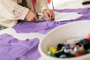 Close-up Of Female Tailor Hands Cutting Material photo