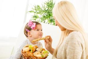 Young Mom Feeds Her Daughter With Pastries photo