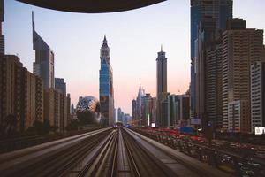 Dubai, UAE, 2022 - metro arrives to metro stop in city of Dubai with scenic modern buildings panorama background photo