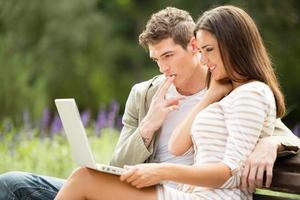 Young Couple Using Laptop At Park photo