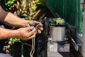 Technician man installing automatic electronic gate in the house. photo