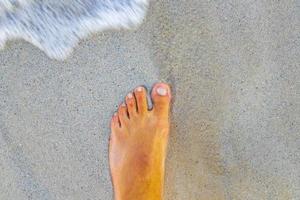 Walking barefoot on the beach sand by the water Mexico. photo