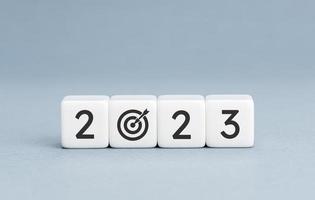 2023 year goal concept. White blocks with 2023 number and goal target icon on blue background. Copy space photo