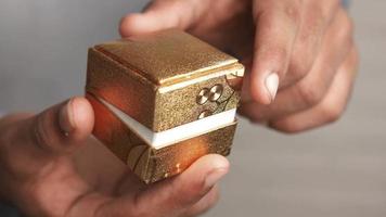 A golden jewelry box with a ring in it