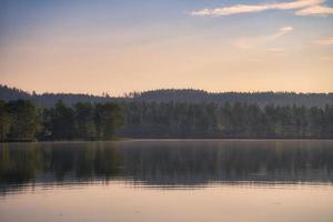 View over a lake in Sweden in Smalland with forest on the other shore. Wild nature photo