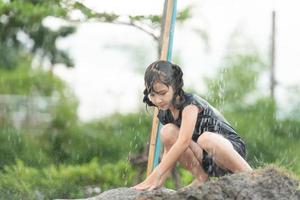 los niños se divierten jugando toboganes de lodo en los campos comunitarios. foto