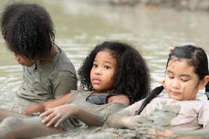 Little girls have fun playing in the mud in the community fields photo