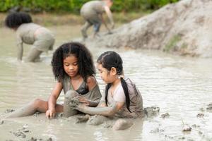 Little girls have fun playing in the mud in the community fields photo