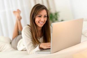 Woman Using Laptop In Bed photo