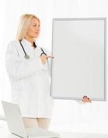 Female Doctor With Noticeboard photo