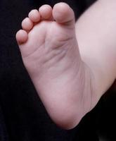pie de bebé sobre un fondo negro foto