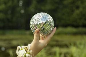 Disco ball in hand. Ball in girl's hand. Mirror. photo