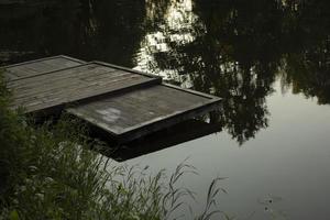 Marina on lake. Empty wharf of boards. Small berth for collecting water from pond. photo