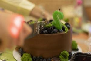 Chocolate cake. Cutting sweet cake. Treat to tea. Sweets on table. photo