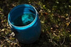barril de agua azul. barril en jardín. agua para regar las plantas. foto