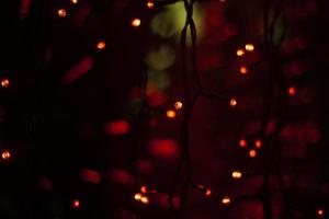 Red garlands on window. Lights in dark. Red lamps. Interior details. photo