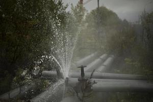 Burst pipe. Water pouring. Pipeline accident. It's dangerous situation. photo