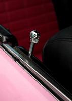 detalle del botón de bloqueo del cráneo en un coche de época rosa foto