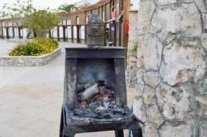 Special iron black metal oven, brazier for the preparation of hot, uncoiled coals for a traditional hookah in Egypt photo