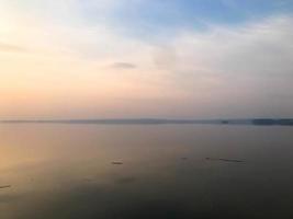 hermosa puesta de sol roja sobre el horizonte del agua en el río, mar, océano, lago foto