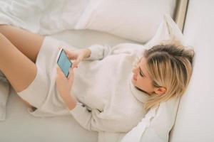 Girl Using Smart Phone In Bed photo