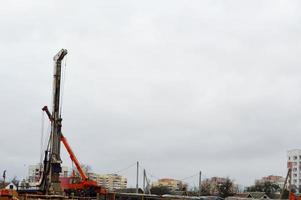 un gran y potente conductor de pilotes de hierro, una máquina de construcción industrial diseñada para levantar, instalar pilotes en el punto de inmersión en el suelo en el lugar de construcción de edificios y casas foto