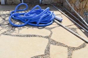 Blue plastic long large corrugated hose for cleaning the pool wash and watering the plants photo