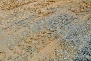 Texture of a dirty bad dirt road dirt road with puddles and clay drying mud with cracks and ruts. Off-road. The background photo