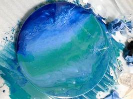 Round interior painting depicting a marine theme. drawing in fluid art technique with epoxy resin with color tint on a wooden background. abstract sea with waves for a photo shoot